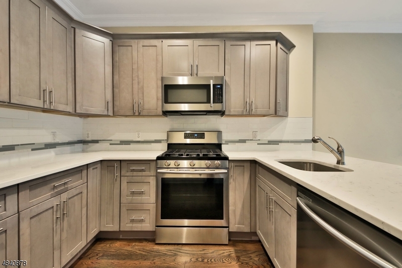 115 Watchung Avenue, Unit 1 Montclair, NJ 07043 - Photo 7 of 15 a kitchen with white cabinets sink and stainless steel appliances