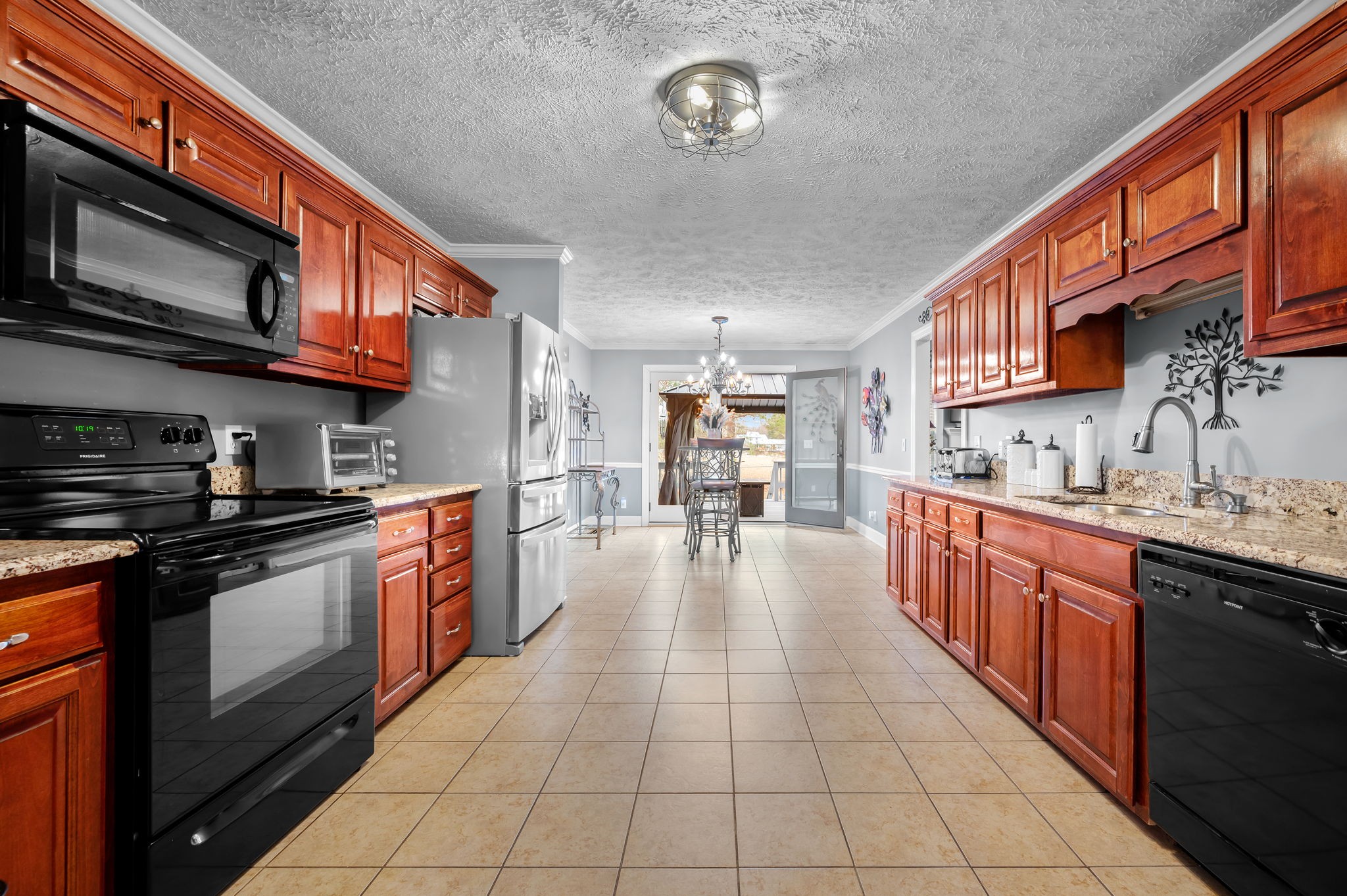 201 Oak Hollow Road Manchester, TN 37355 - Photo 14 of 43 a large kitchen with stainless steel appliances granite countertop a large stove top oven a sink dishwasher a dining table and chairs with wooden cabinets