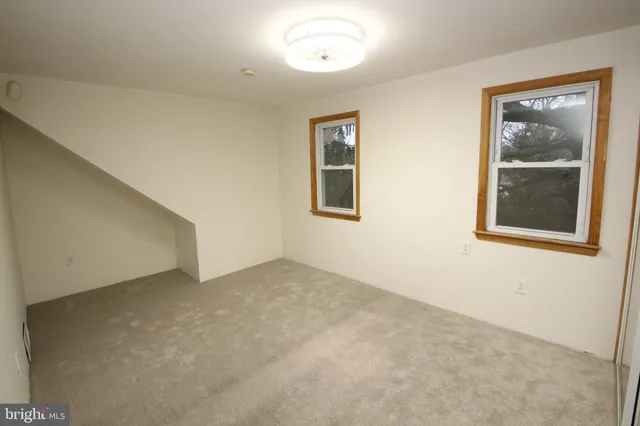 an empty room with windows and closet