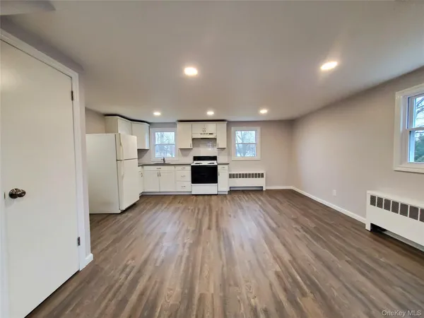 a view of kitchen with wooden floor and electronic appliances