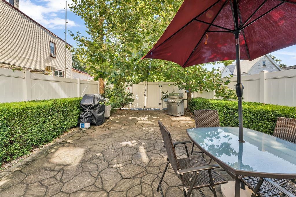 129 Prospect Street, Unit 3 Jersey City, NJ 07307 - Photo 29 of 34 a view of a backyard with table and chairs under an umbrella
