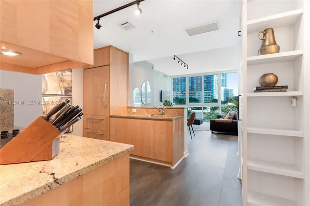 a kitchen with stainless steel appliances kitchen island granite countertop a stove and a sink