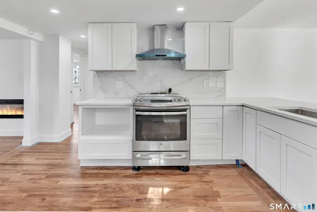 a kitchen with granite countertop a stove a sink and a refrigerator