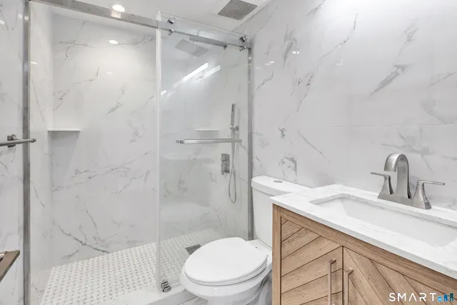 a bathroom with a sink a toilet and shower