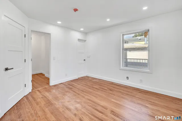 a view of empty room with wooden floor