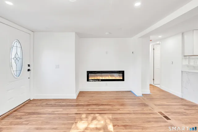a view of a room with wooden floor and white walls