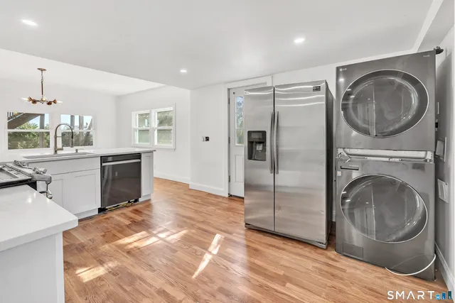 a view of a kitchen with a sink washer and dryer