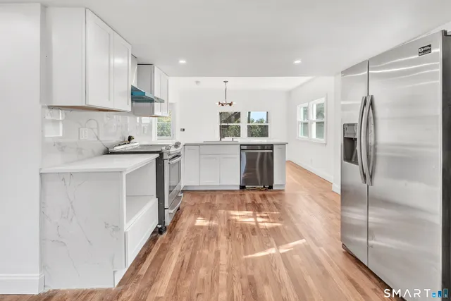 a kitchen with a sink refrigerator and cabinets