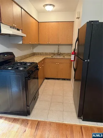 a kitchen with stainless steel appliances granite countertop a refrigerator and a stove