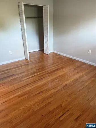 an empty room with wooden floor and closet