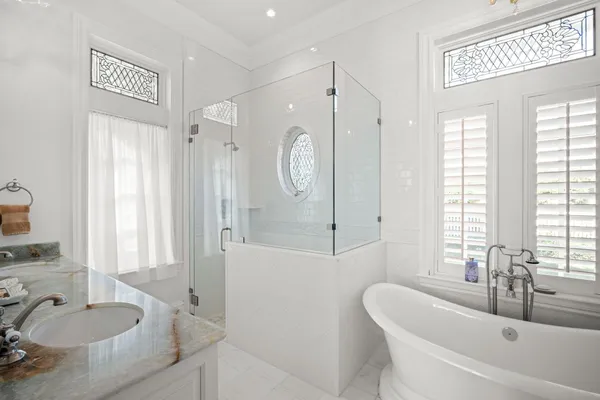 a bathroom with a granite countertop double vanity sink and mirror