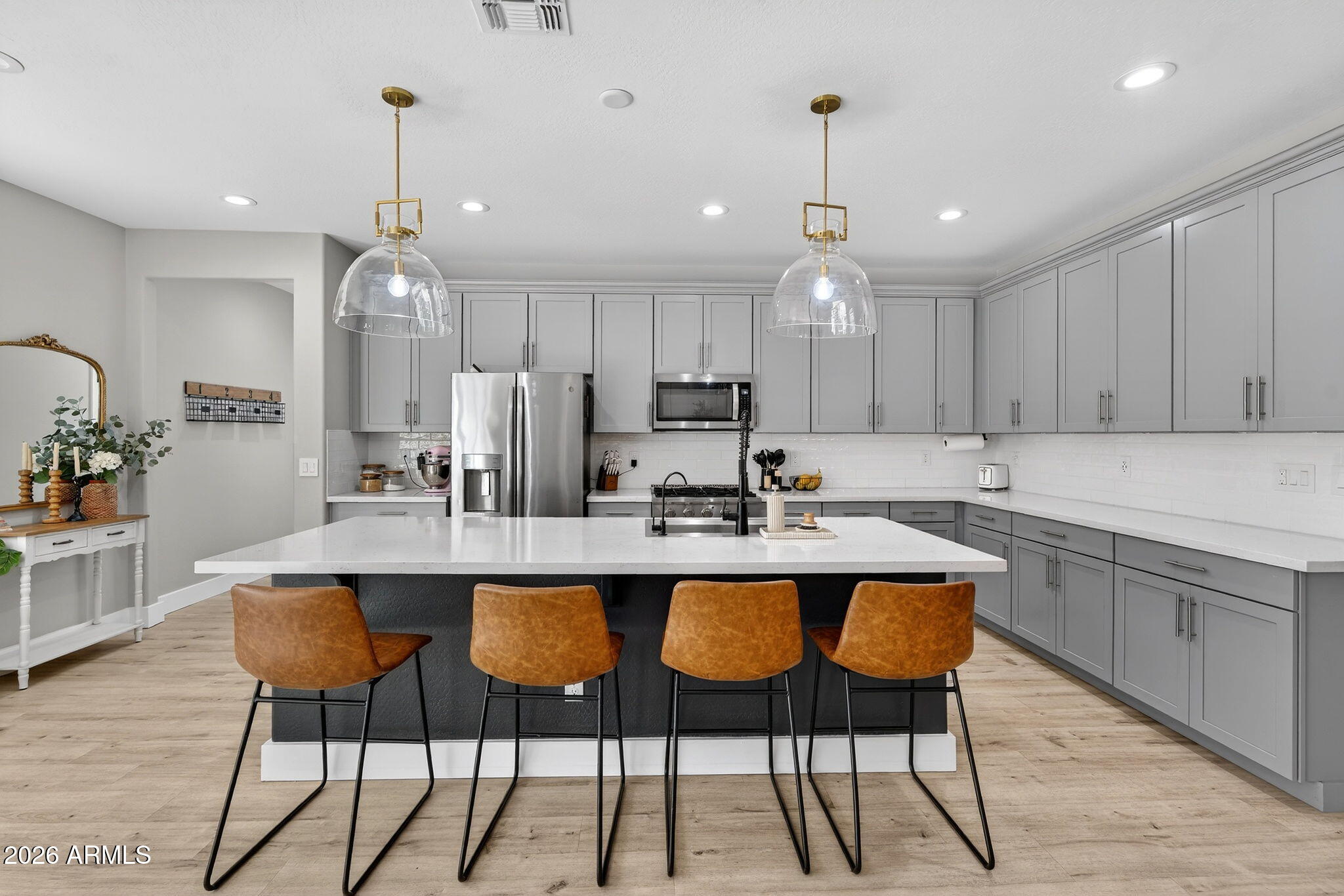 1663 West Gordon Street San Tan Valley, AZ 85144 - Photo 13 of 54 a kitchen with granite countertop a table chairs stove microwave and cabinets with wooden floor