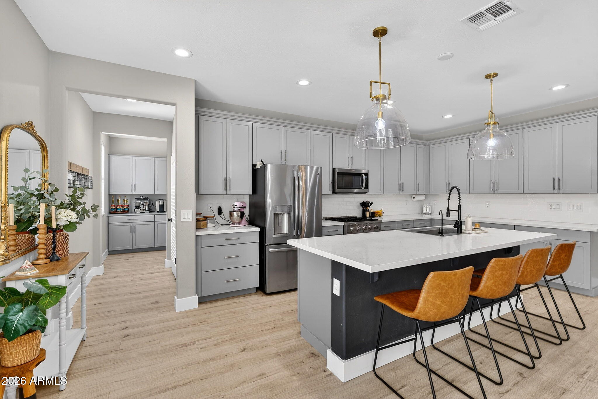 1663 West Gordon Street San Tan Valley, AZ 85144 - Photo 14 of 54 a kitchen with a sink a center island stainless steel appliances and cabinets