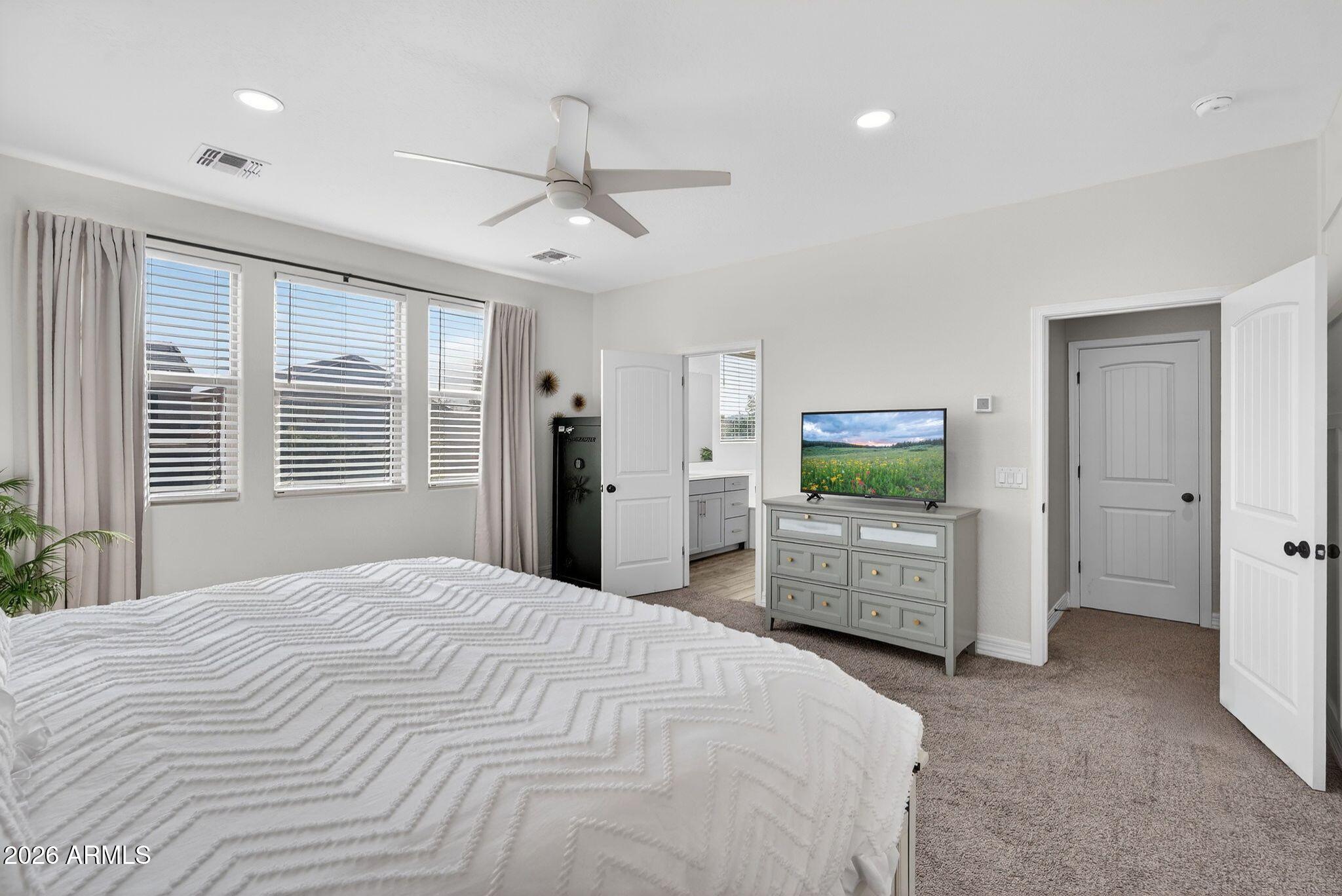 1663 West Gordon Street San Tan Valley, AZ 85144 - Photo 27 of 54 a bedroom with a large bed and a flat screen tv