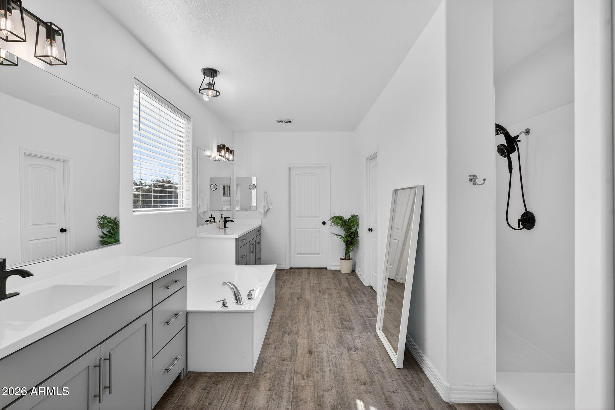 1663 West Gordon Street San Tan Valley, AZ 85144 - Photo 28 of 54 a spacious bathroom with a double vanity sink a two mirror a window and a shower