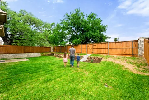 a view of backyard with a barn and large trees