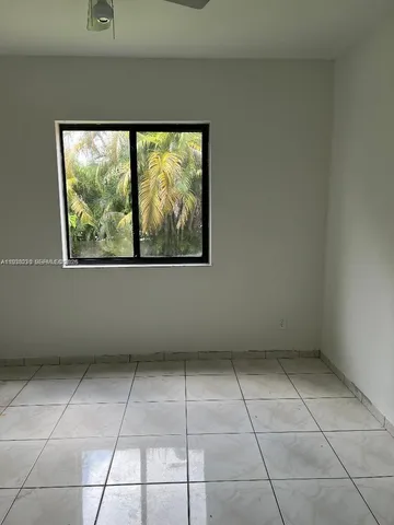 a dining room with furniture and a floor to ceiling window