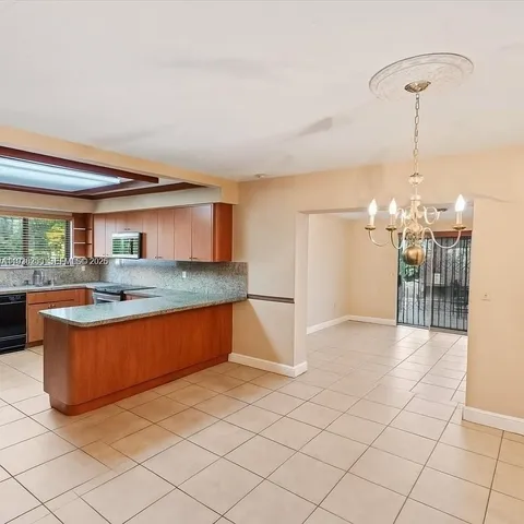 a large kitchen with kitchen island a sink stainless steel appliances and cabinets