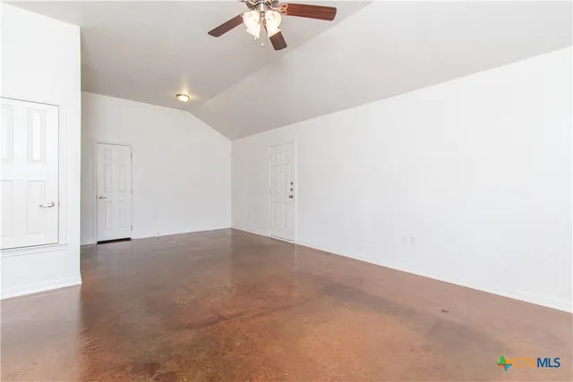 a view of an empty room with a ceiling fan