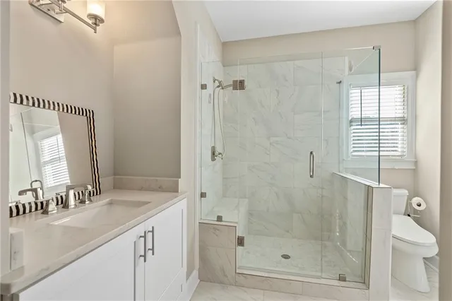 a bathroom with a toilet a sink a mirror and a window