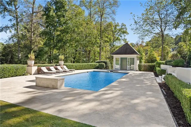 a view of a hallway with chandelier wooden floor and windows