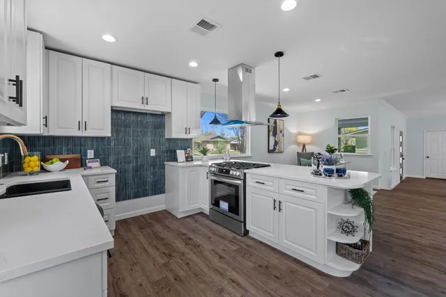 a kitchen with white cabinets and stainless steel appliances