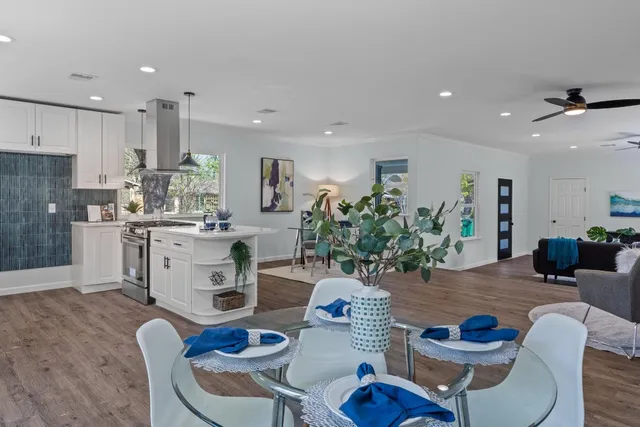 a kitchen with stainless steel appliances a stove a sink dishwasher and white cabinets with wooden floor