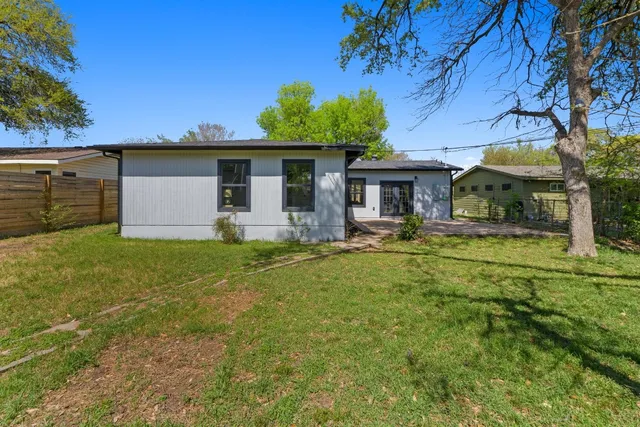 a view of a house with backyard and a tree