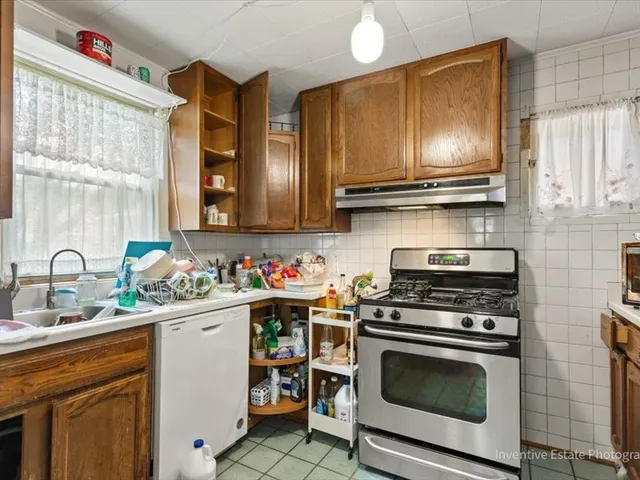 a kitchen with a sink stove top oven and cabinets