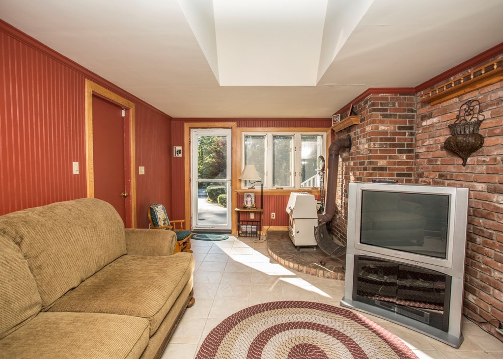 138 Sarah Sherman Road Rochester, MA 02770 - Photo 26 of 30 a living room with furniture a flat screen tv and a fireplace