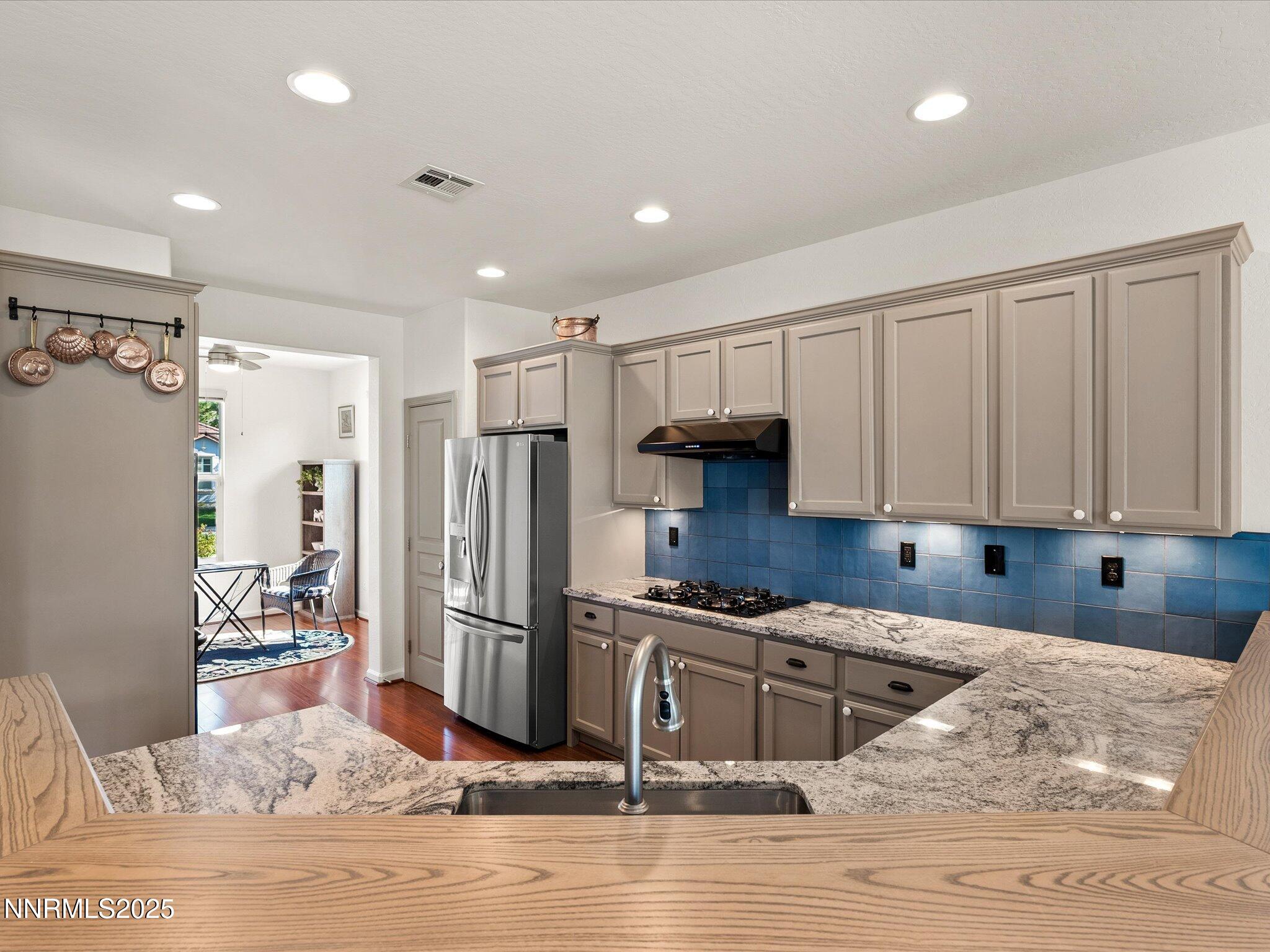 9052 Cabin Creek Trail Reno, NV 89523 - Photo 10 of 34 a kitchen with granite countertop a refrigerator and a stove top oven