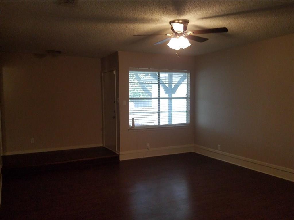 6919 West Cleburne Road Fort Worth, TX 76133 - Photo 6 of 15 Spacious interior with dark wood-finish flooring, a ceiling fan with integrated lighting, and a large window featuring horizontal blinds