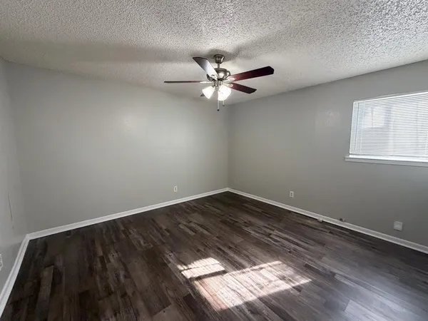 a view of a room with wooden floor and a ceiling fan