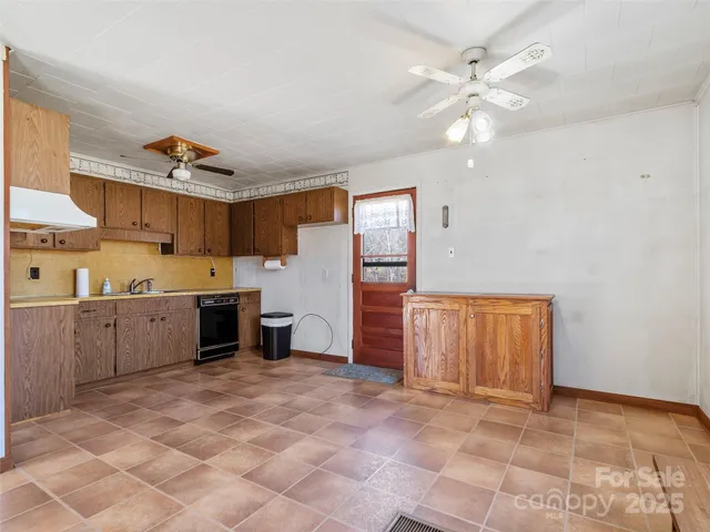 a large white kitchen with a sink cabinets and window