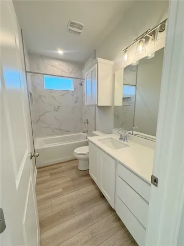 a bathroom with a double vanity sink mirror and toilet