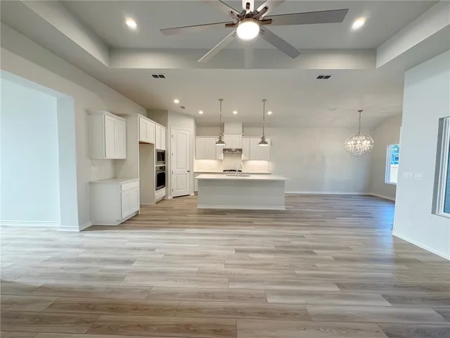 a view of a kitchen with kitchen island a sink stainless steel appliances and cabinets