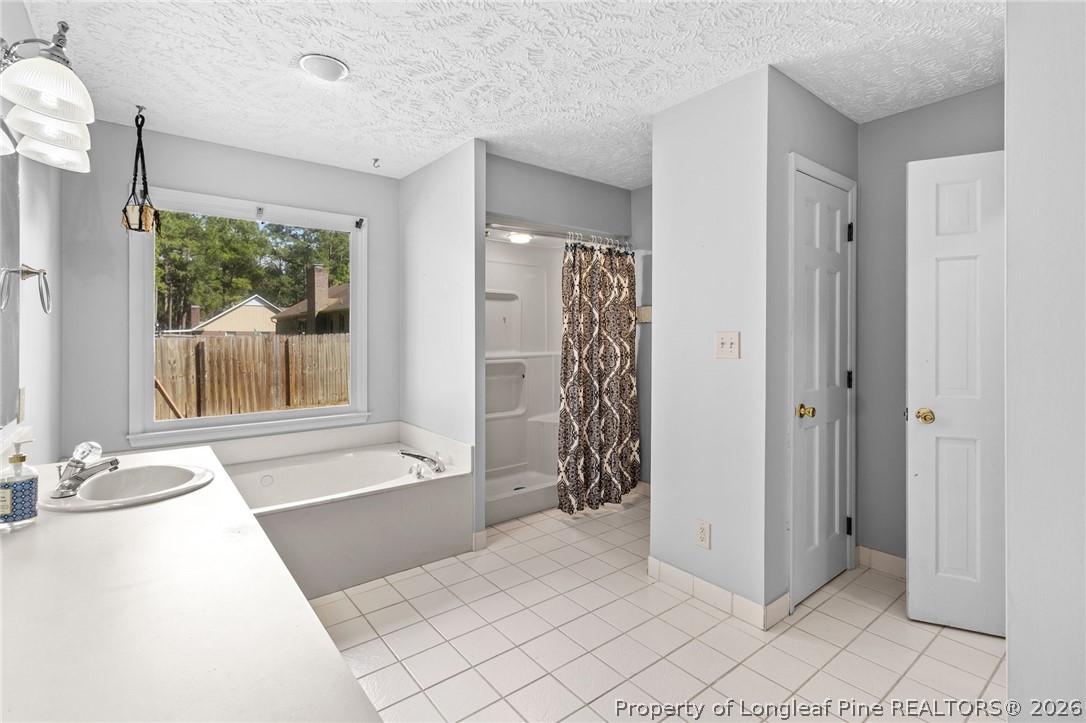 7756 Dragonhead Road Fayetteville, NC 28311 - Photo 18 of 42 a bathroom with a tub shower and sink