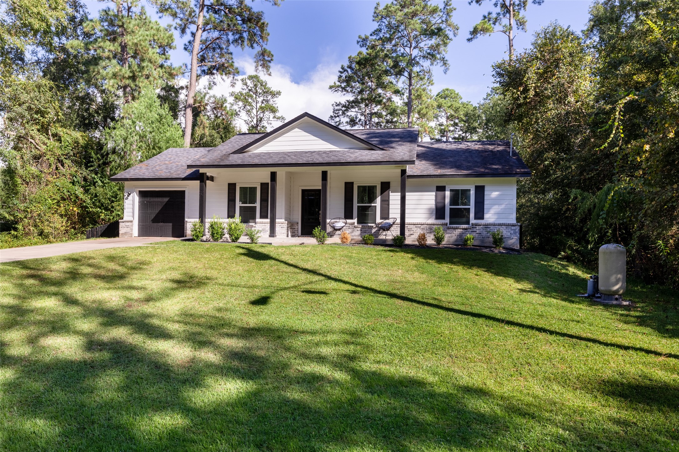 a view of house with a yard potted plants and a table