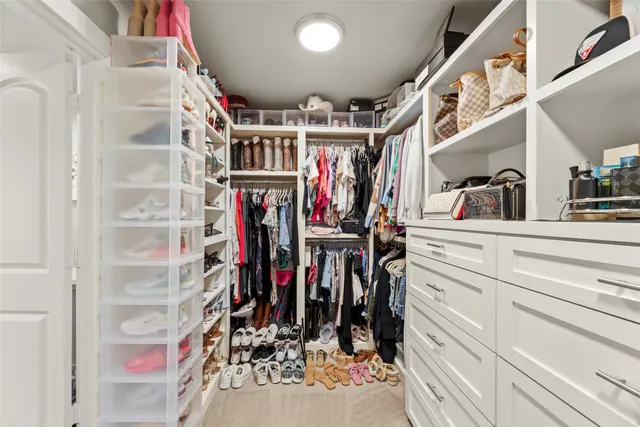 a view of walk in closet with clothes