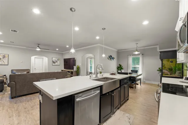 a large kitchen with a counter top space and stainless steel appliances