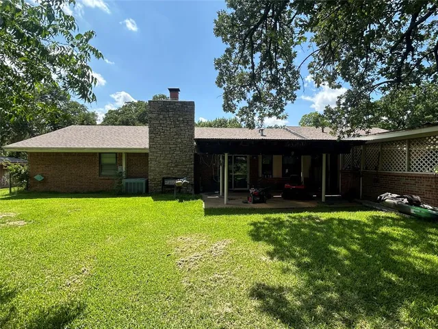 a front view of a house with a yard and trees