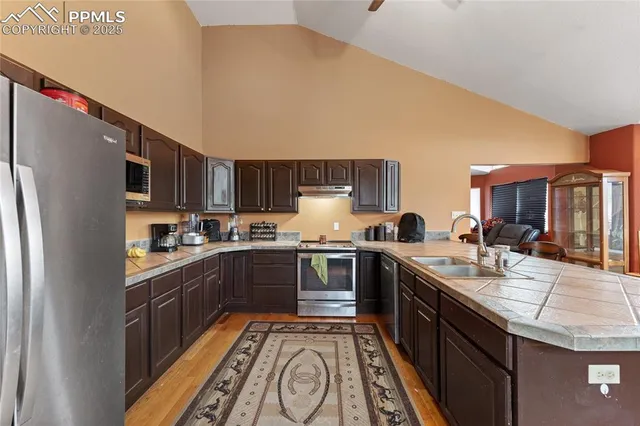 a large kitchen with stainless steel appliances granite countertop a sink and cabinets