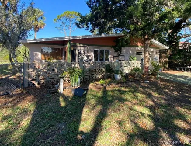 a front view of house with yard and trees around
