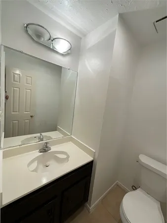 a bathroom with a sink toilet and mirror