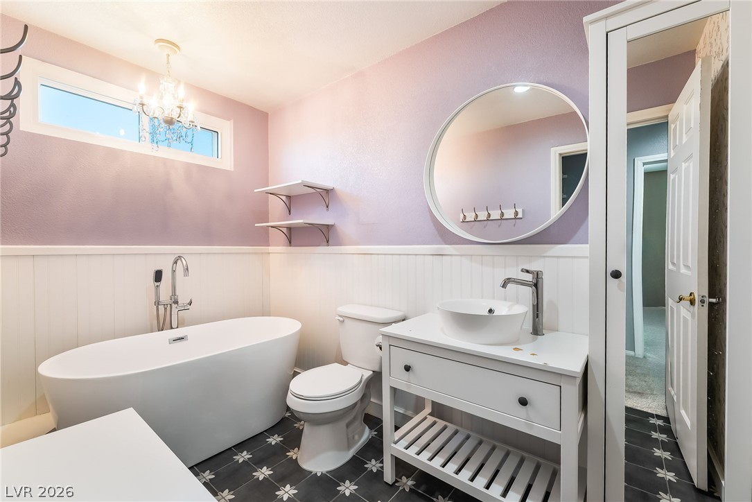 261 Timber Hollow Street Henderson, NV 89012 - Photo 41 of 51 A chic bathroom offers a deep soaking tub and a vanity with an elegant vessel sink.