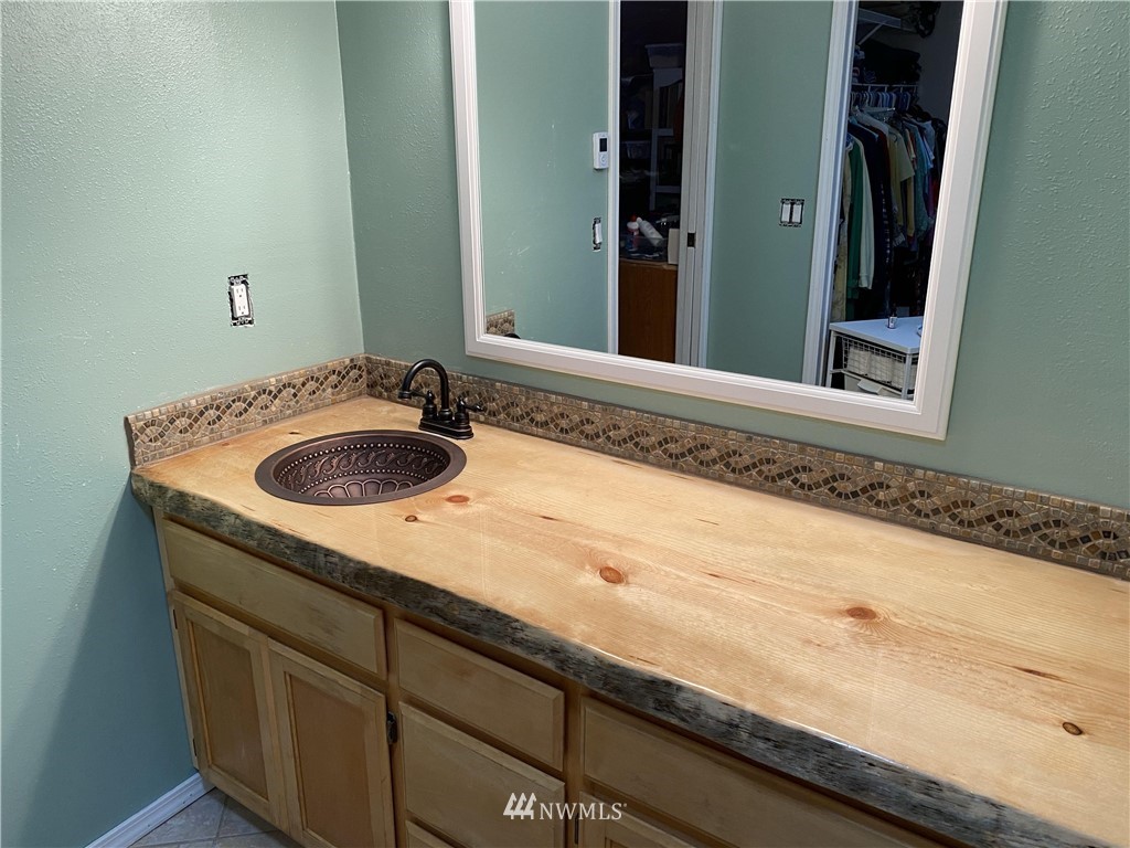 8209 177th Lane Southwest Rochester, WA 98579 - Photo 14 of 39 a bathroom with a granite countertop sink and a mirror