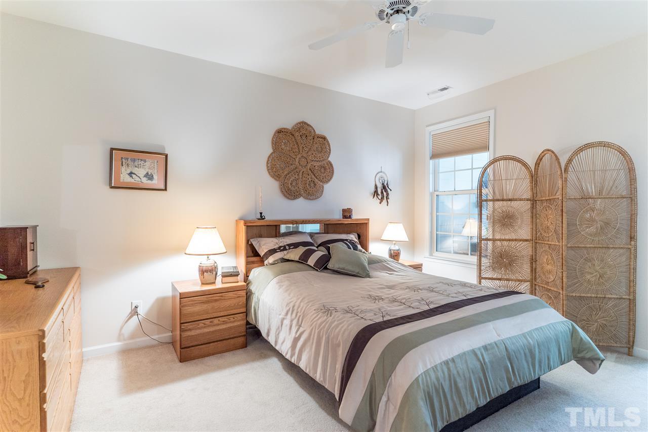 10423 Dapping Drive Raleigh, NC 27614 - Photo 12 of 25 a bedroom with a bed and a chandelier