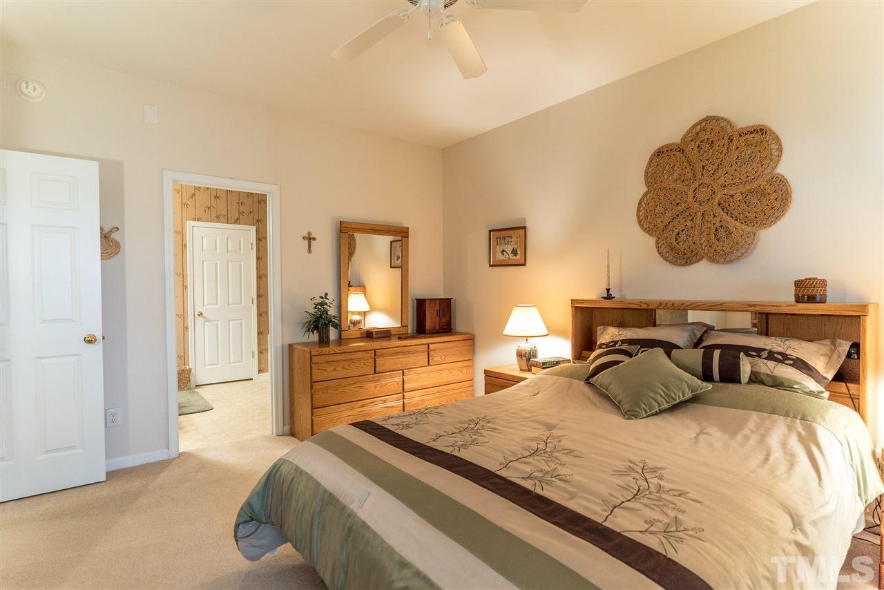 10423 Dapping Drive Raleigh, NC 27614 - Photo 13 of 25 a bedroom with a bed and a chandelier