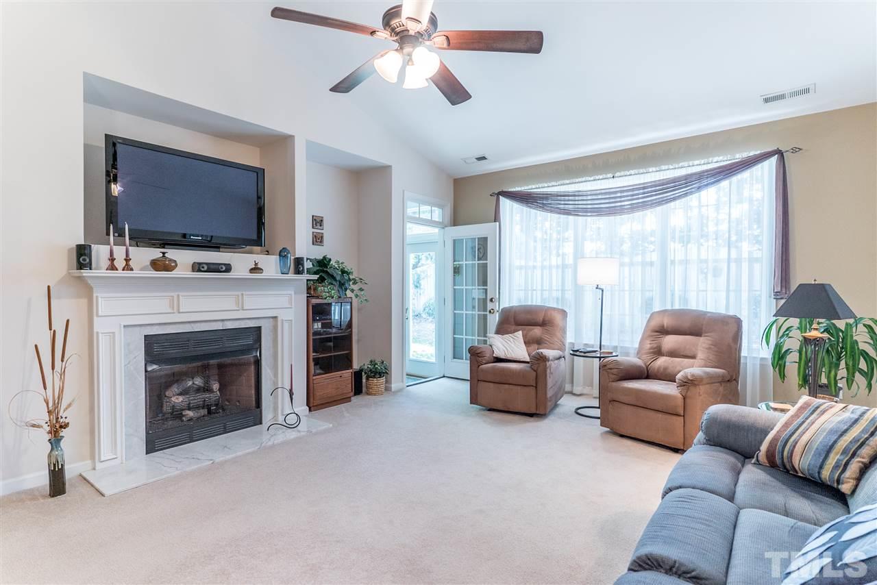 10423 Dapping Drive Raleigh, NC 27614 - Photo 10 of 25 a living room with furniture a flat screen tv and a fireplace