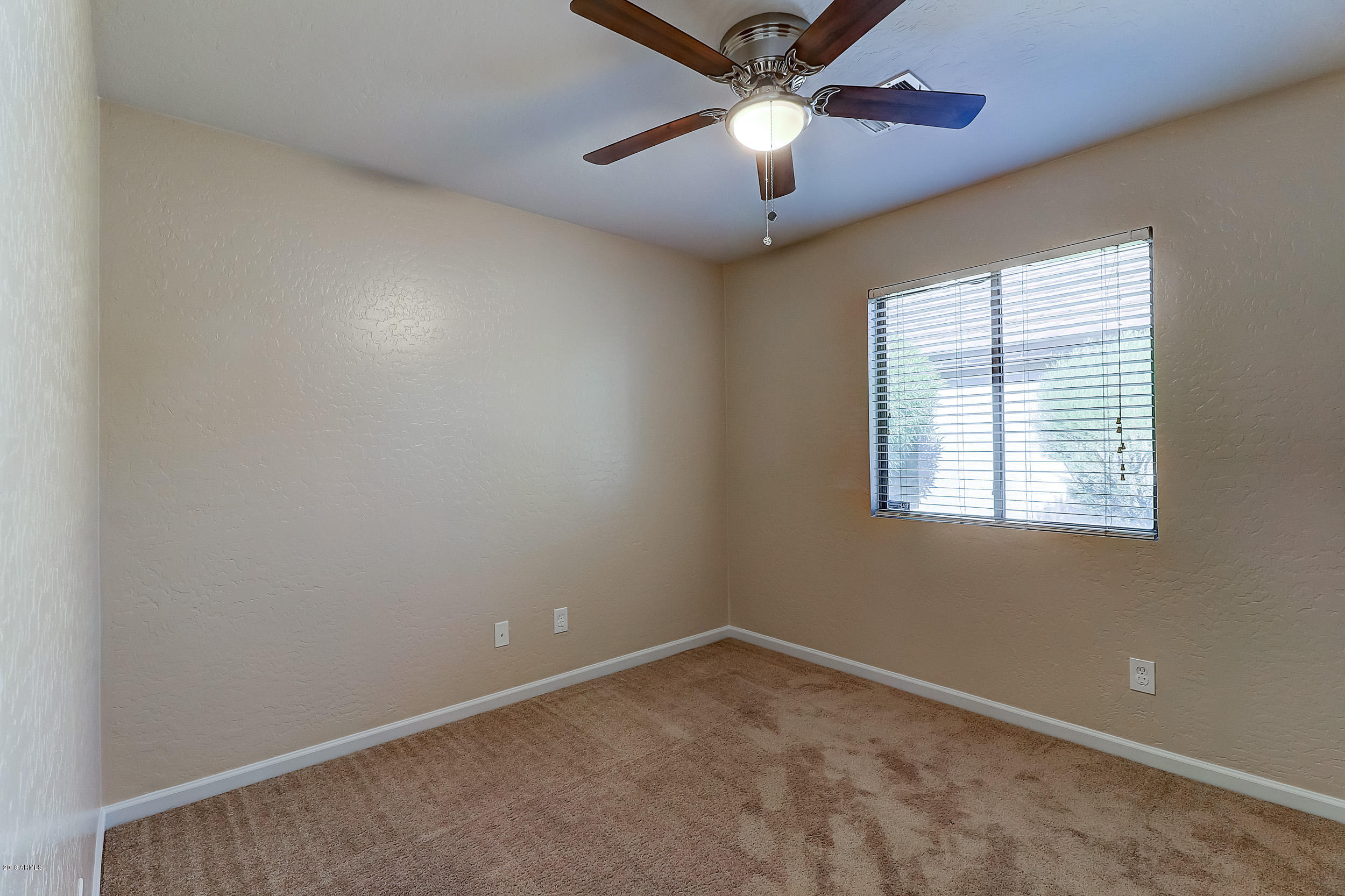 14726 West Calavar Road Surprise, AZ 85379 - Photo 18 of 24 an empty room with a window and a fan